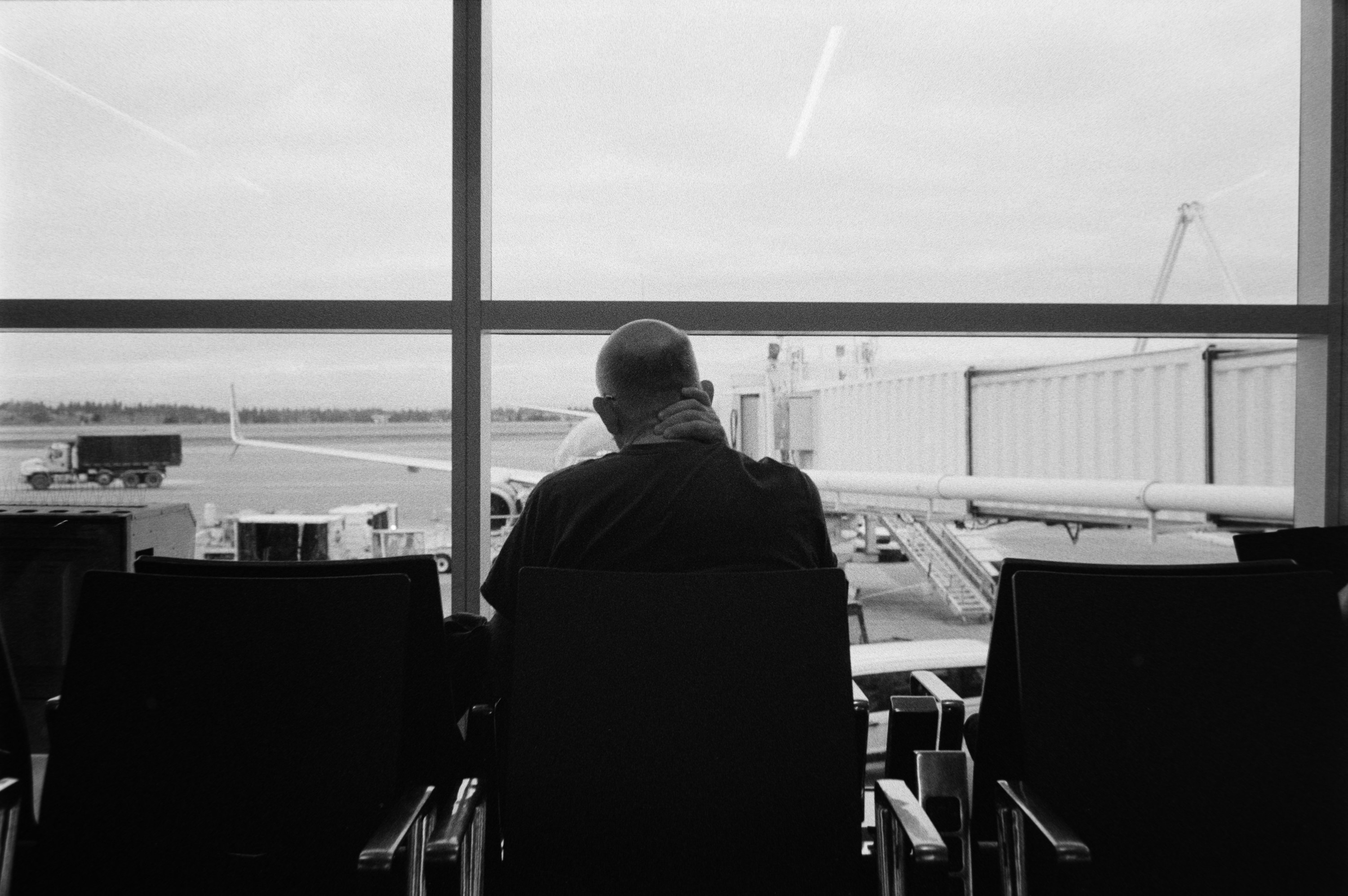 Traveler looking over the airport apron while waiting for a flight